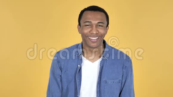 年轻的非洲男人指着镜头黄色背景视频的预览图