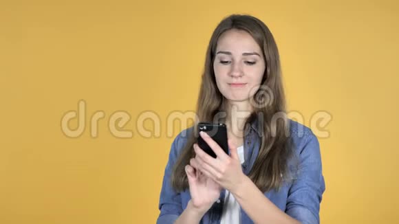 黄色背景下智能手机受惊的美女视频的预览图