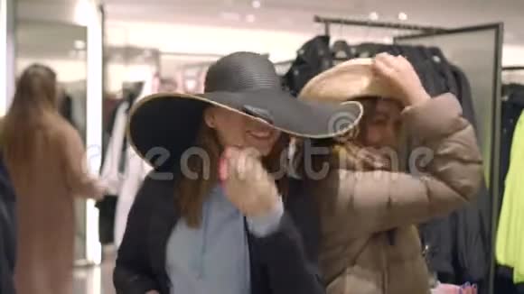 朋友们正在准备冬天的暑假在商店里试穿帽子视频的预览图
