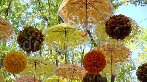 明亮的橙色和黄色的伞和球在风中悬挂和移动视频的预览图