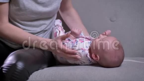 母亲与可爱的新生女儿在客厅拥抱的特写肖像视频的预览图