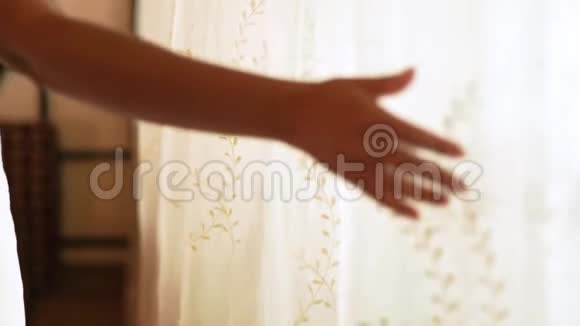在舒适的卧室里女性用手触摸白色的窗帘卧室里裹着浴巾的年轻女子房屋设计视频的预览图
