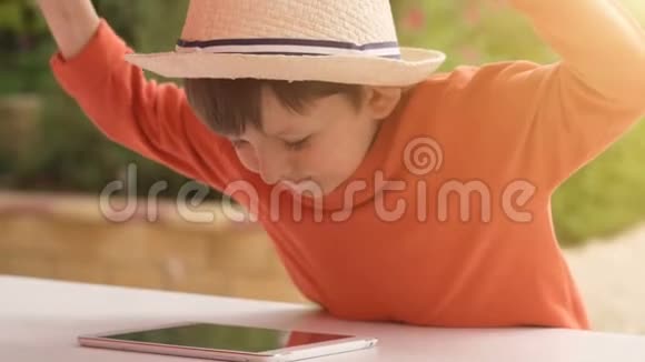 夏日大自然背景下玩平板电脑的小男孩视频的预览图