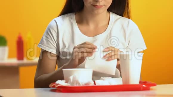 女性在快餐店饭后用餐巾擦嘴特写视频的预览图