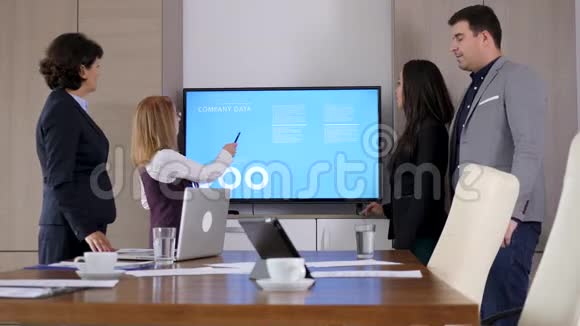 大屏幕电视前会议室的商业伙伴视频的预览图