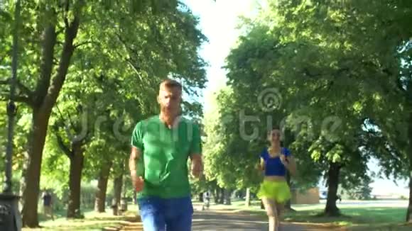 快乐的女跑步者超过了公园的人视频的预览图