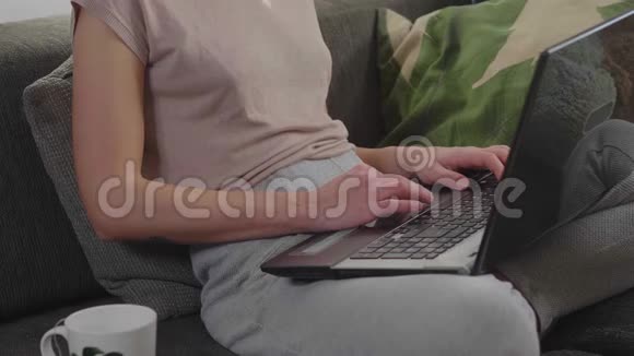 漂亮的女孩坐在客厅里上网视频的预览图