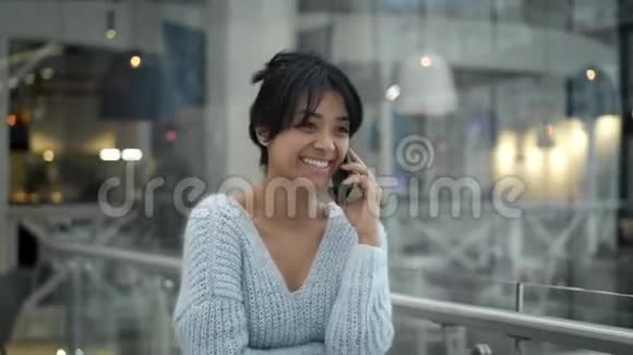中档亚洲女性走路时在电话中笑视频的预览图
