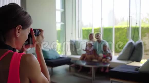 女摄影师拿着一张全家福照到大厅里的相机上躺在一张悬空的床上慢动作视频的预览图