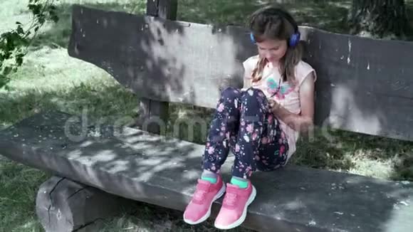 坐在长凳上听音乐的女孩视频的预览图