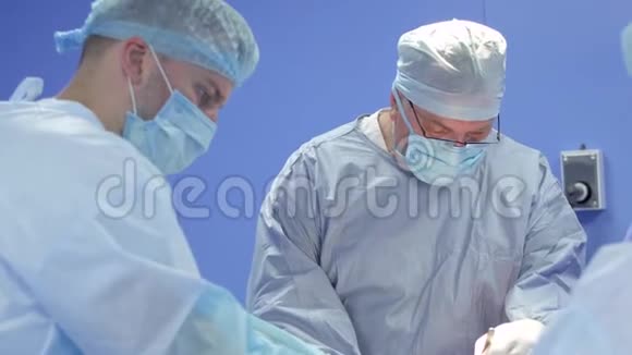 外科医生在蓝色手术室为病人做手术视频的预览图