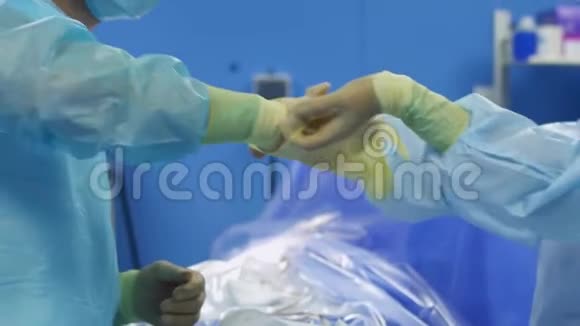 护士帮助外科医生把乳胶手套戴在手上视频的预览图