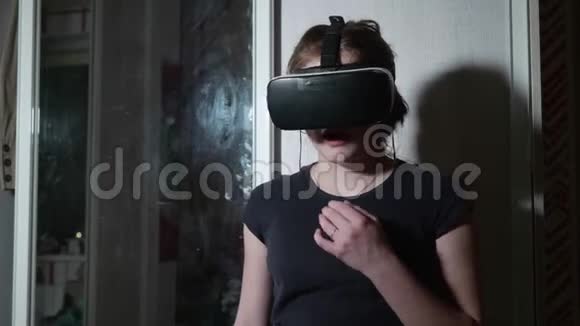 穿着巴尔克T恤的戴VR眼镜的白人女孩既害怕又担心女孩害怕现实视频的预览图