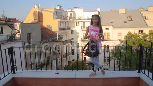 女孩站在阳台上走出框架视频的预览图