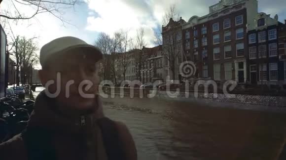 在荷兰阿姆斯特丹沿着城市运河散步的年轻人视频的预览图