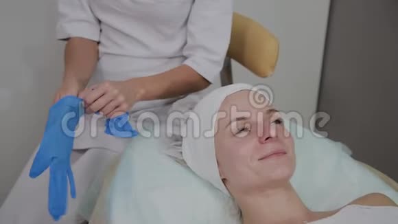 专业美容师戴蓝色橡胶手套进行手术视频的预览图