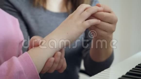 年轻的女人教小女孩如何正确地握住手视频的预览图