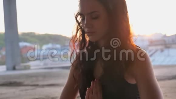 瑜珈女孩的脸在夕阳西下的一座废弃的建筑里双手捧着娜玛斯卡健康的生活方式视频的预览图