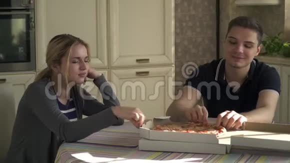年轻夫妇在厨房吃披萨视频的预览图