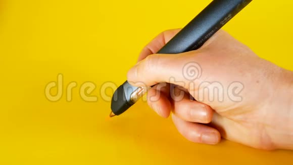 一个男人用3d打印机笔在黄色背景下画画这是创新技术等主题的理想画面视频的预览图