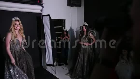 女孩金发模特穿着闪亮的连衣裙戴着皇冠在工作室拍照视频的预览图