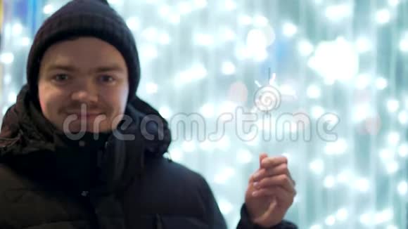微笑快乐穿着冬装的年轻人在模糊蓝灯背景假日和圣诞节上闪耀视频的预览图