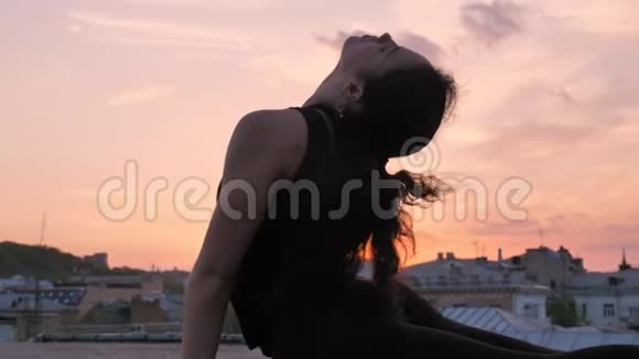 Yogi女孩站在眼镜蛇的姿势下夏天在日落时分登上屋顶健康的生活方式放松的理念视频的预览图