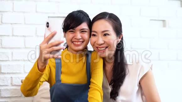 快乐的亚洲十几岁的女儿和中年母亲在视频中打电话视频的预览图