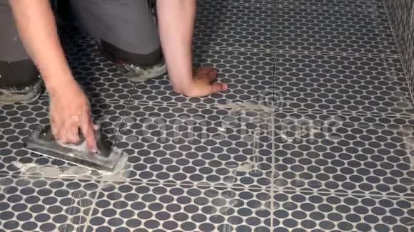 工人用手用浆液填补瓷砖之间的缝隙视频的预览图