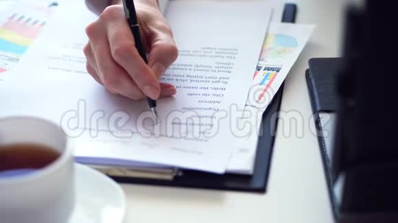 在办公桌上用笔记本电脑时的手在写东西在白色桌面上有一个白色的视频的预览图