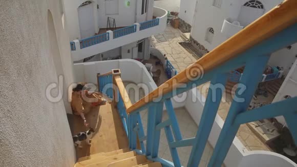 旅游妇女坐在楼梯上穿着黄色衣服的人来参观达哈布视频的预览图