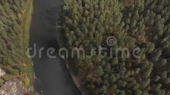 慢无人驾驶飞机飞越平缓的山河松林海岛垂直视图视频的预览图