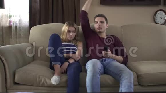 男的拥抱女朋友和她一起在家看电视视频的预览图