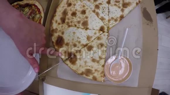 手拿刀切块披萨放入塑料盘万能顶球视频的预览图