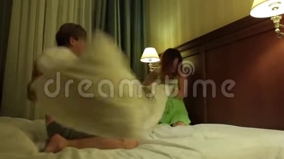 战枕年轻夫妇玩得很开心丈夫和妻子在床上胡闹打架枕头视频的预览图