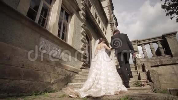 新娘带领新郎进入城堡新婚夫妇散步快乐视频的预览图
