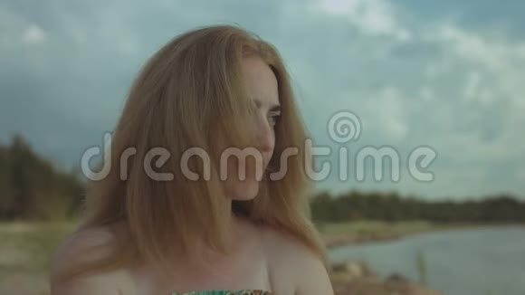 忧郁的姜女在海边休息的肖像视频的预览图
