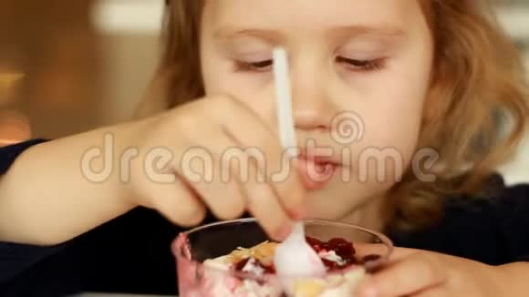 小女孩在咖啡馆里吃甜食特写儿童肖像视频的预览图