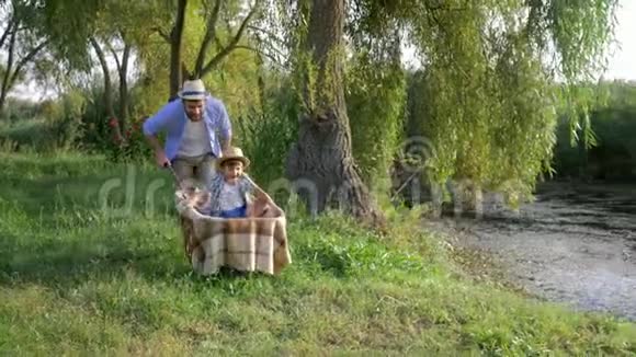 一家人在乡下度假快乐的父亲在小河在小河边的手推车里胡闹视频的预览图