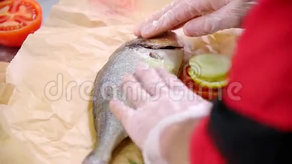 在厨房工作的厨师把鱼装满蔬菜然后用油抹鱼视频的预览图