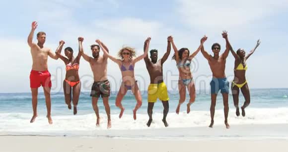 混合种族朋友在海滩上跳跃的正面景色视频的预览图