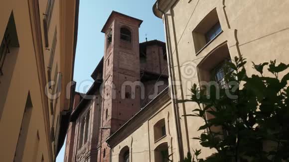 意大利帕维亚的一座老教堂房子和工厂之间有钟楼视频的预览图