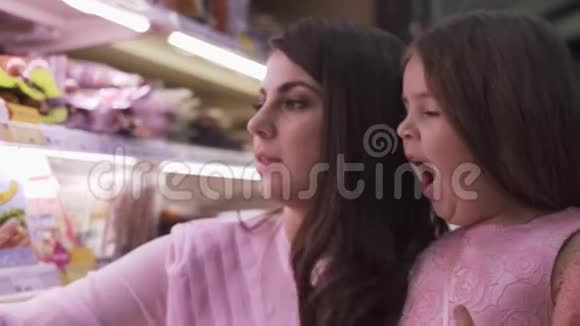 妈妈和女儿在杂货店的货架上挑选食物视频的预览图