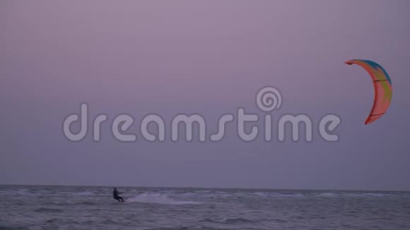 慢动作射击男子控制训练风筝在波浪上在黎明时射击视频的预览图