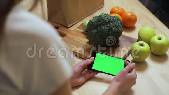 美国纽约2019年3月5日特写女性的手浏览智能手机与色度键在厨房在家早餐视频的预览图