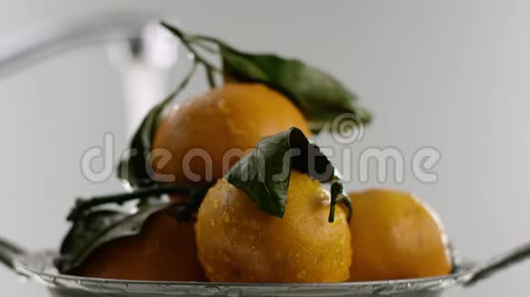 在视频中我们看到橘子橘子躺在滑梯上橘子上覆盖着水滴在背景上我们可以看到视频的预览图