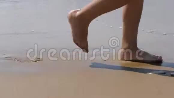 孩子沿着海浪走幼儿波浪背景上的脚海水冲走了脚印视频的预览图