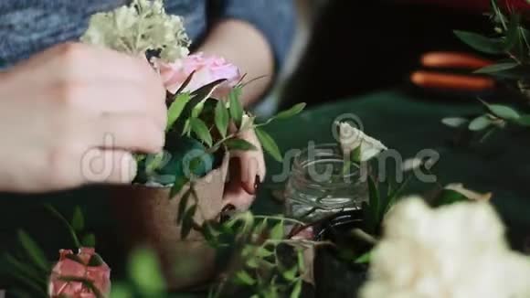 女孩用人造花收集花盆视频的预览图