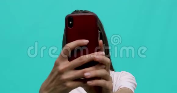 蓝色背景智能手机自拍的女人视频的预览图