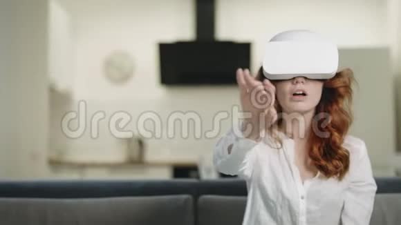 漂亮的女士在现代厨房用虚拟眼镜玩互动视频的预览图